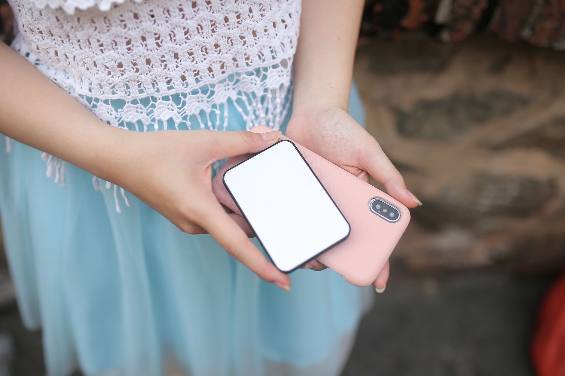 Close-up of a woman holding a smartphone and power bank, showcasing technology and connectivity.