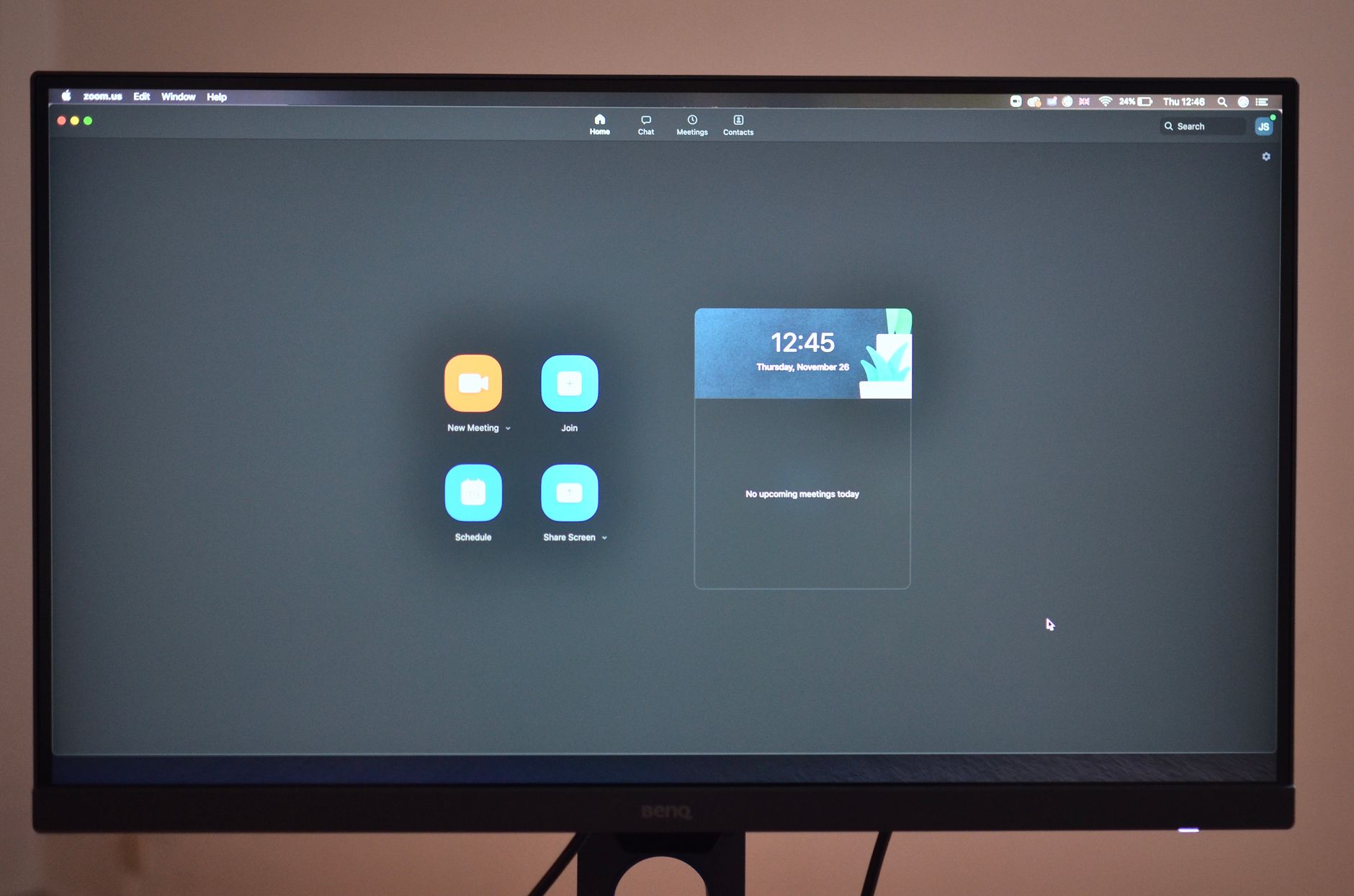 Contemporary stationary black rectangular monitor showing time on display with wires placed on brown background at convenient workplace in r