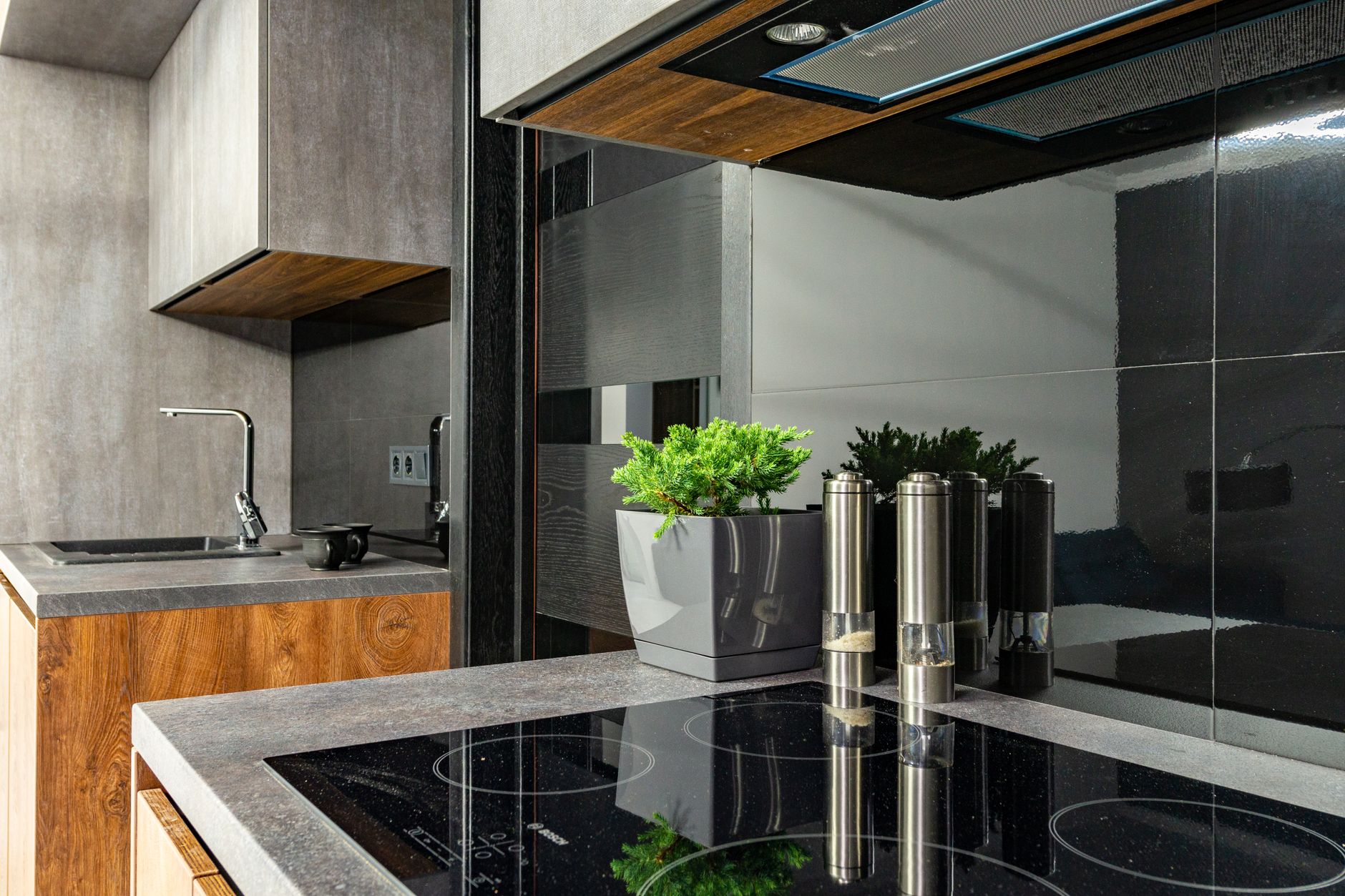 Contemporary kitchen interior featuring a stylish induction cooktop, stainless steel fixtures, and minimalist design.