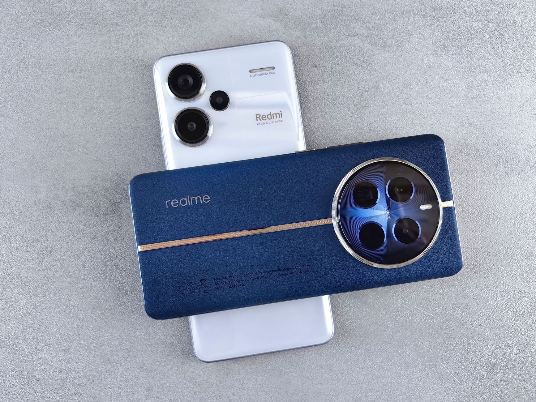 Close-up view of Realme and Redmi smartphones placed on a grey textured surface, showcasing modern technology design.