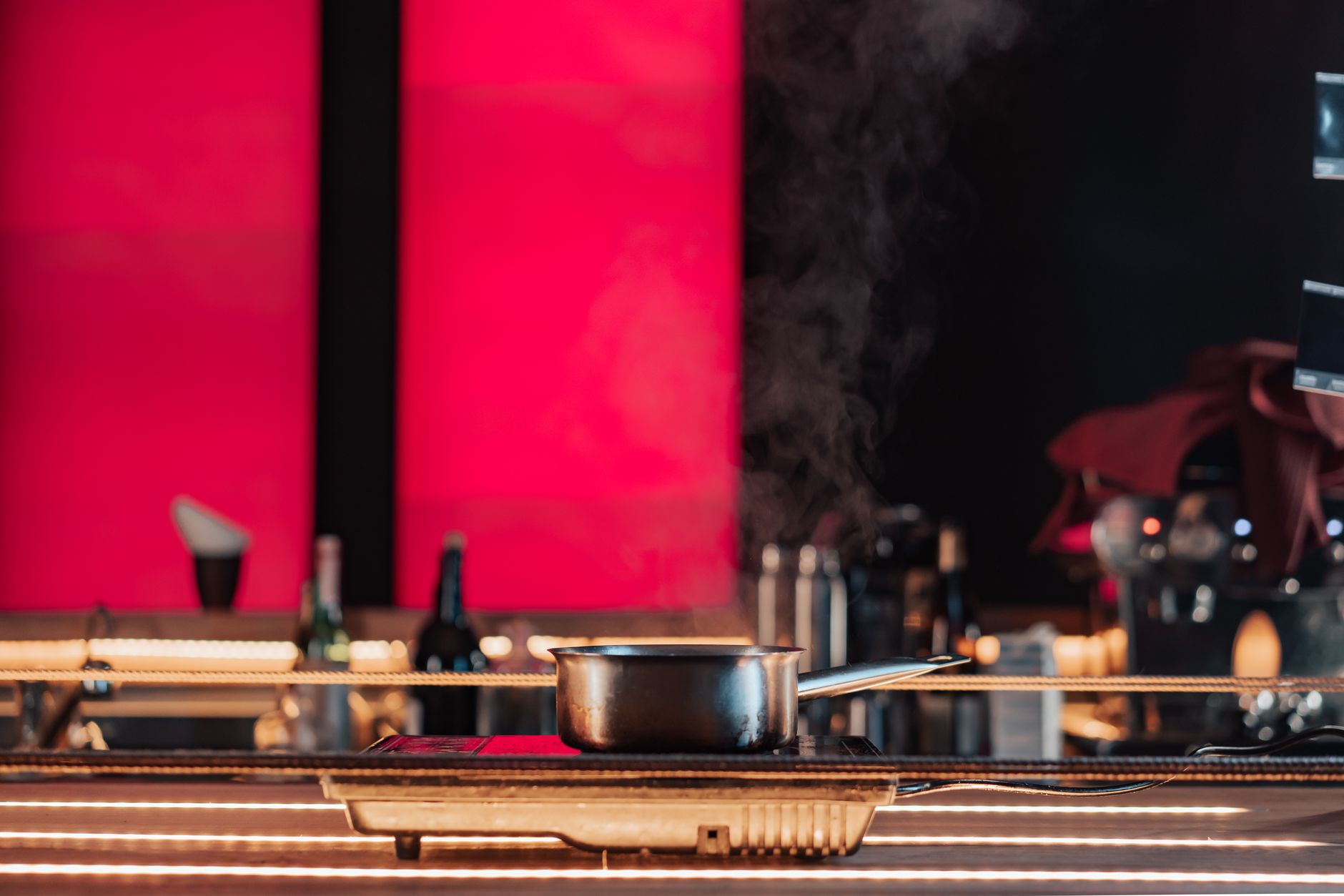 A modern kitchen setup with a steaming pot on an electric stove, perfect for restaurant settings.