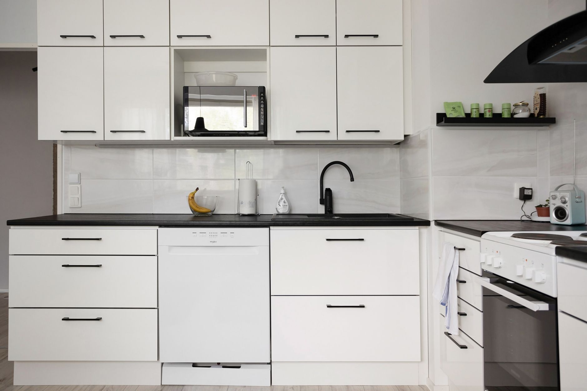 Sleek and modern white kitchen with appliances, showcasing contemporary interior design.
