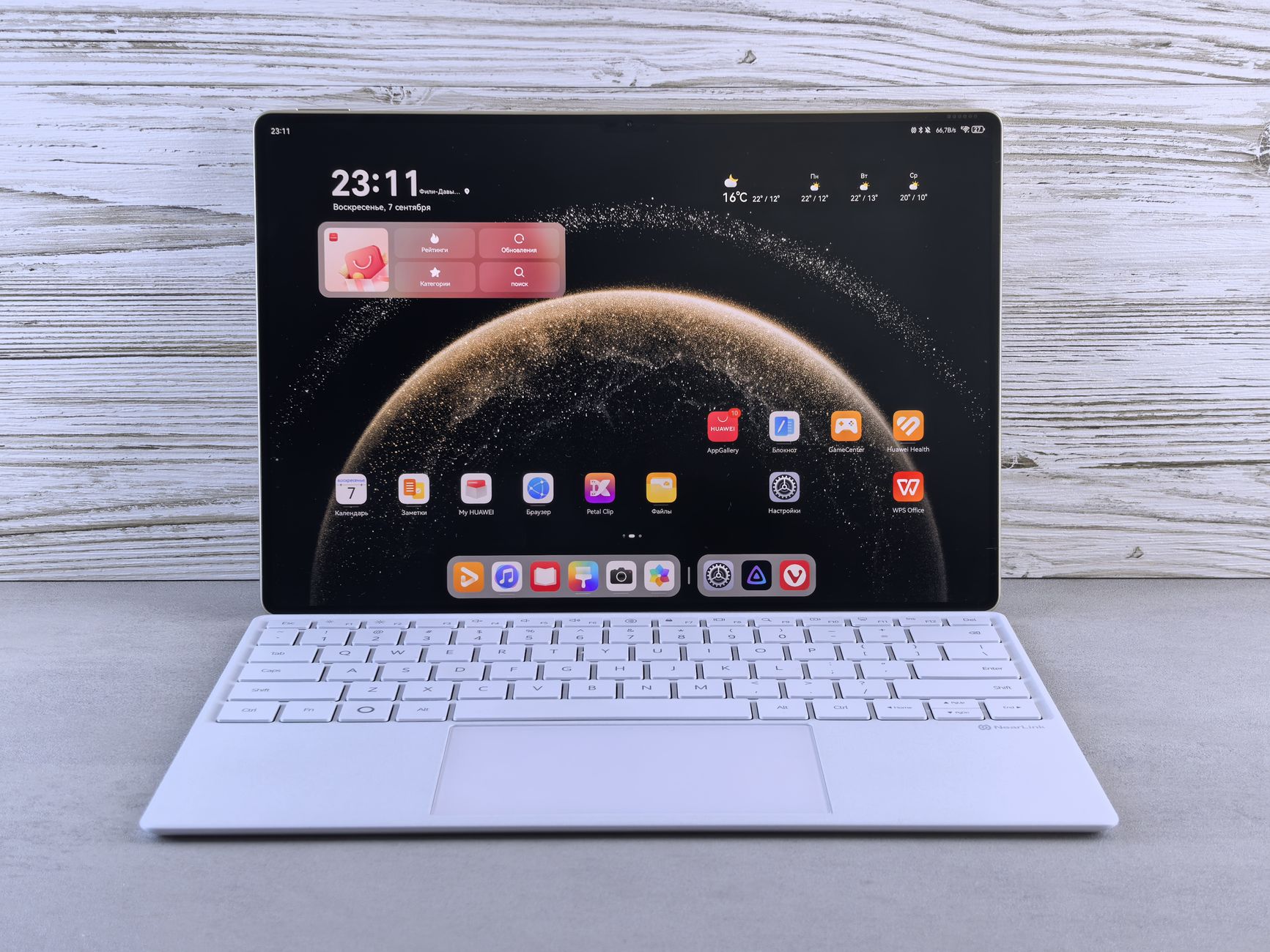 A sleek tablet with a keyboard showing a digital interface, against a wooden background.